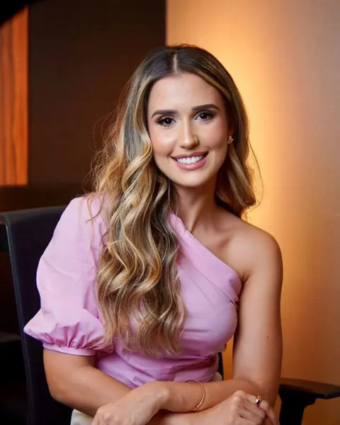 Dra. Fernanda Araújo sentada, sorrindo